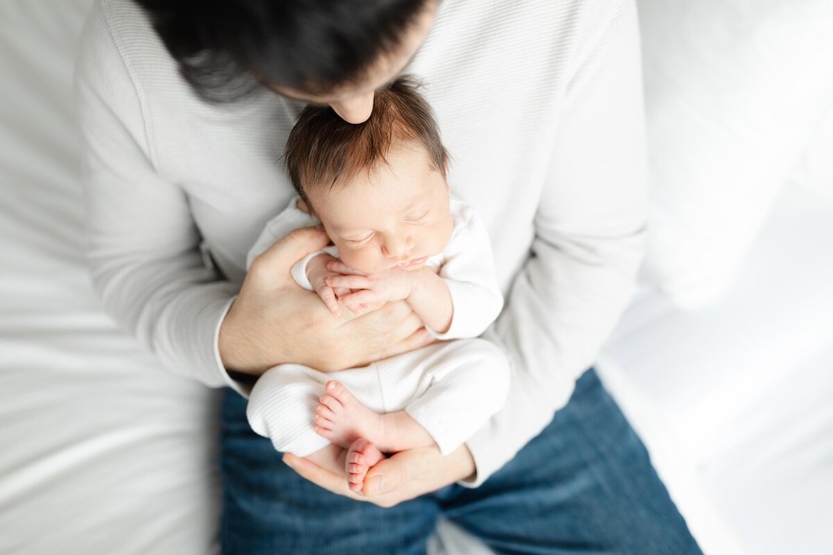 Dad holding baby in lap overhead shot for newborn session in DC