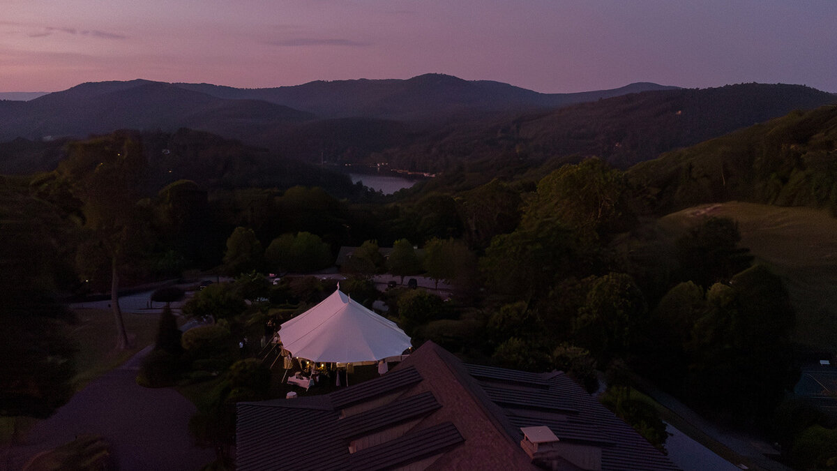 Aerial drone image of sailcloth tent wedding reception at sunset in Highlands, North Carolina.