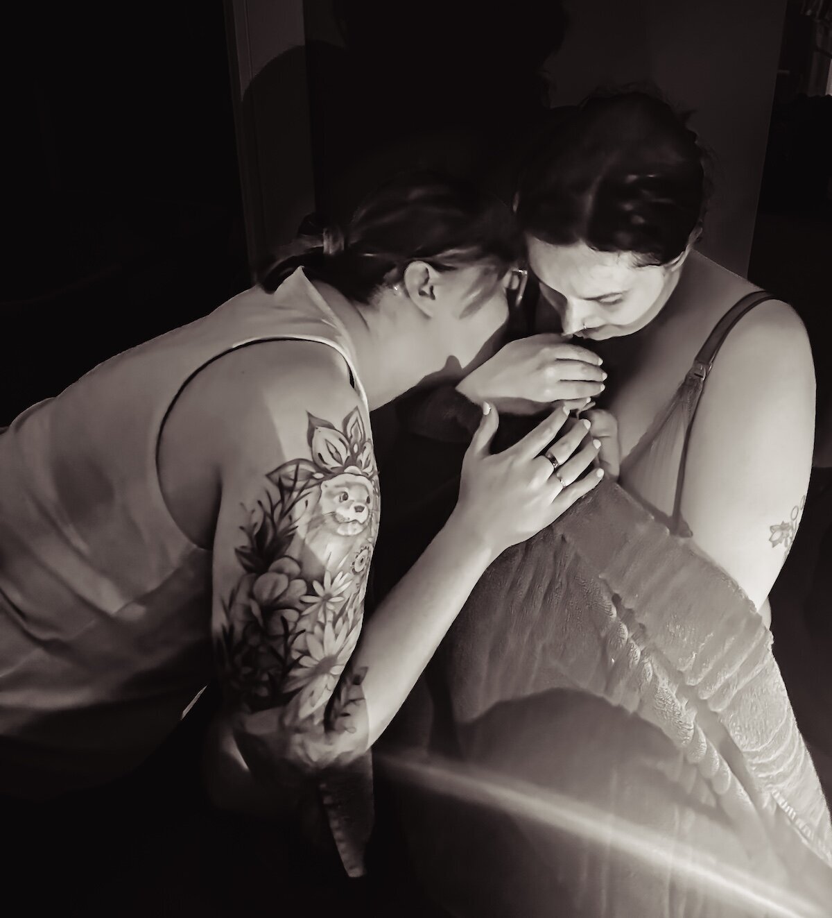 lesbian couple embrace after the birth of their child
