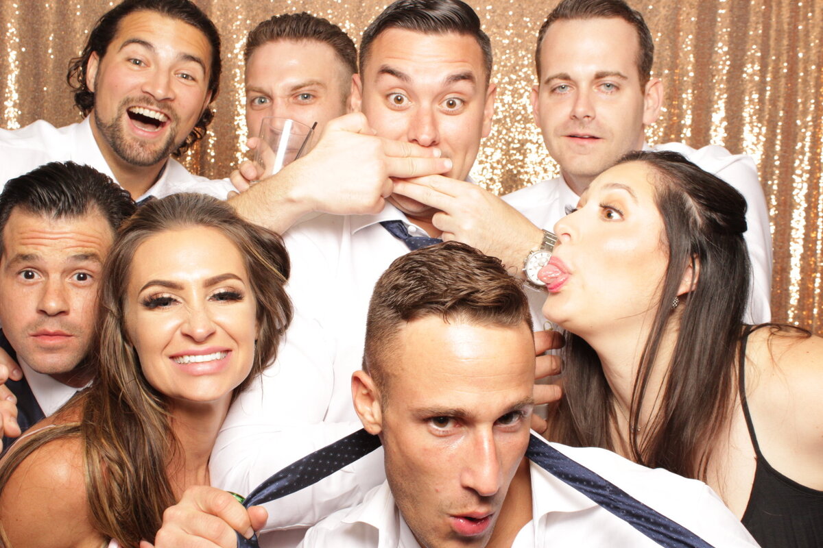 friends having fun in a photo booth at wedding
