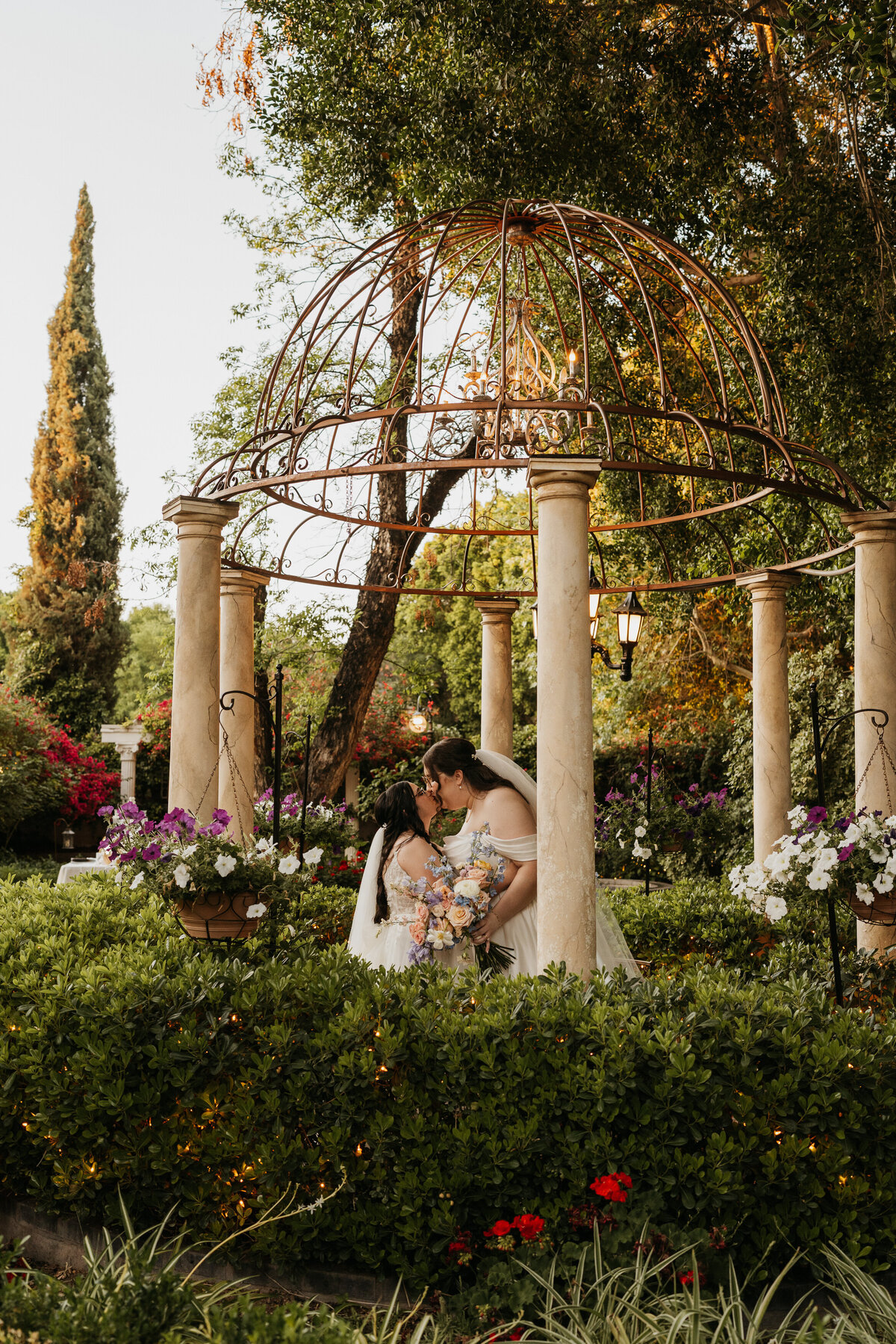 A newlywed couple kissing under a gazebo 