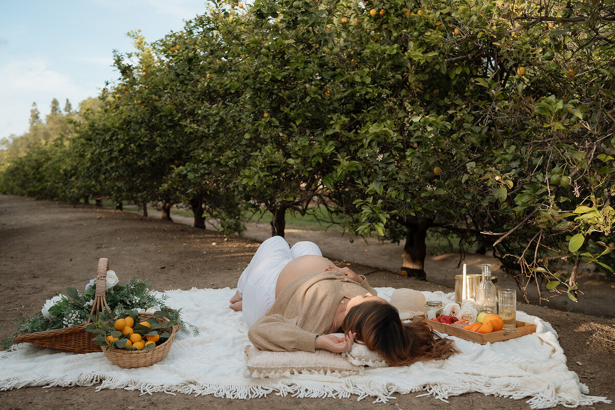 mom laying down in orchard during maternity session