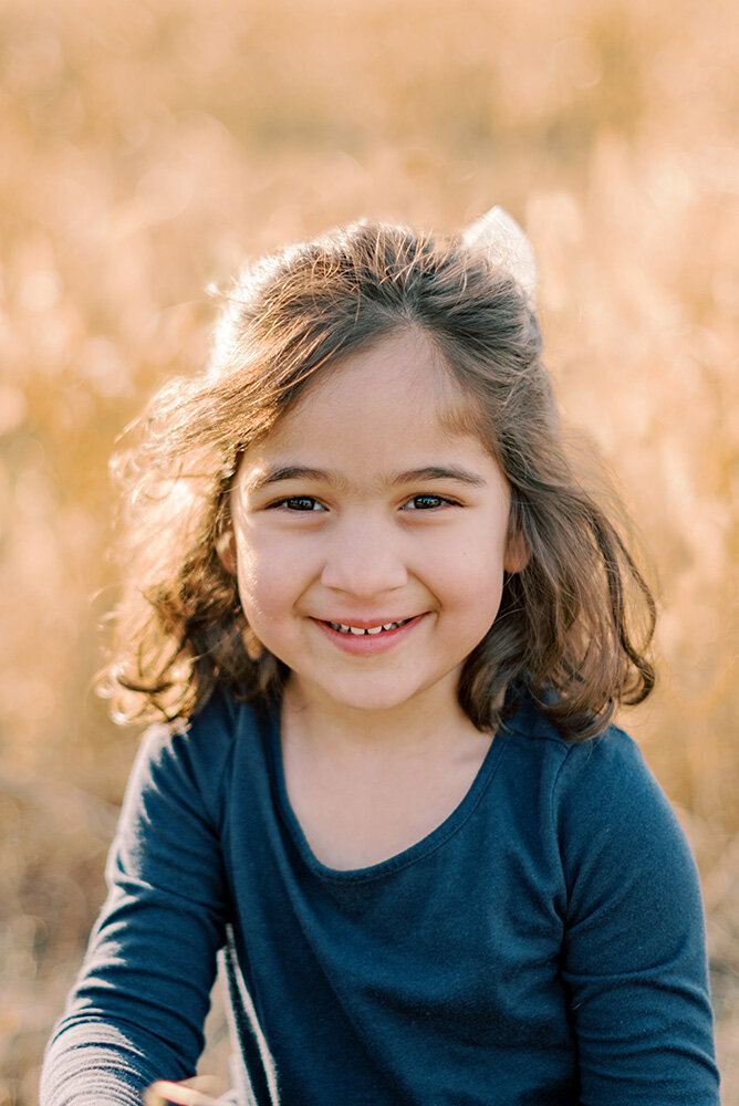 Toddler girl portrait in a field of yellow grass