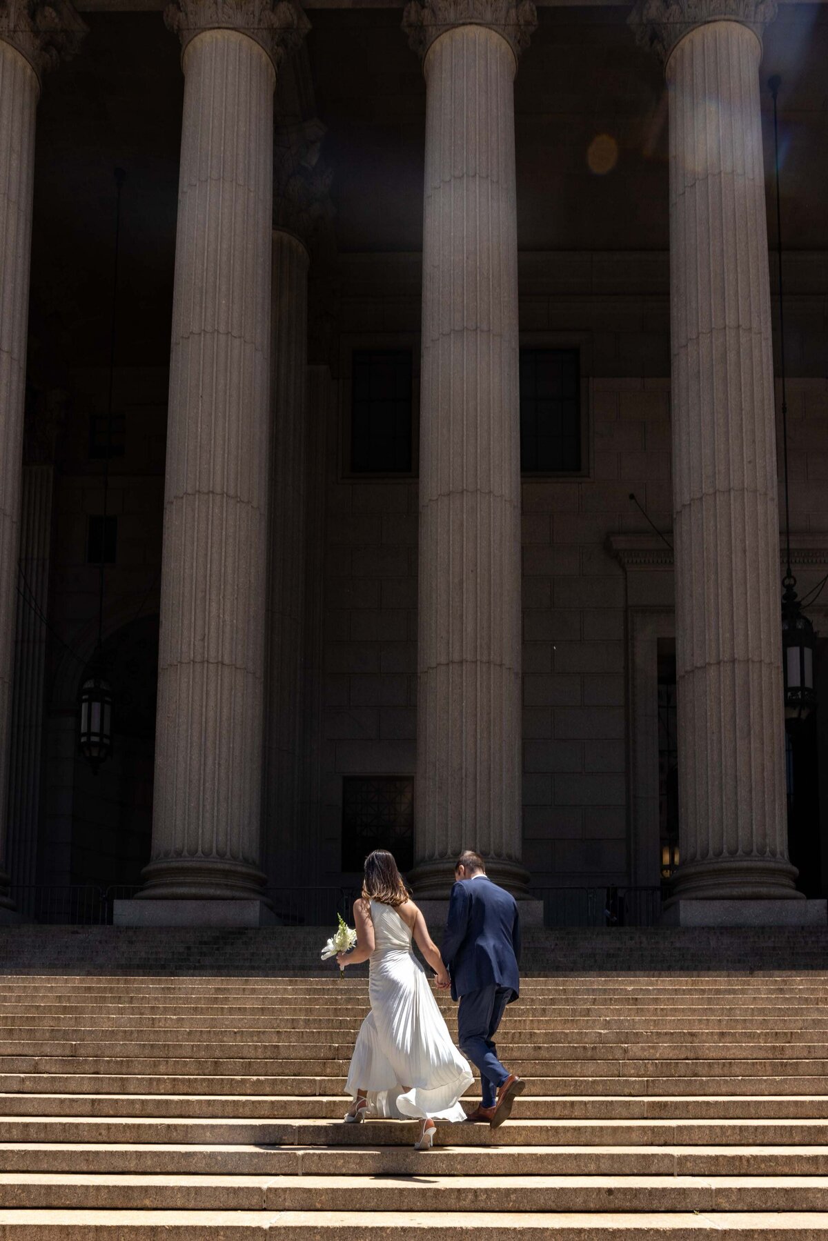 A couple walking up a large set of stairs.