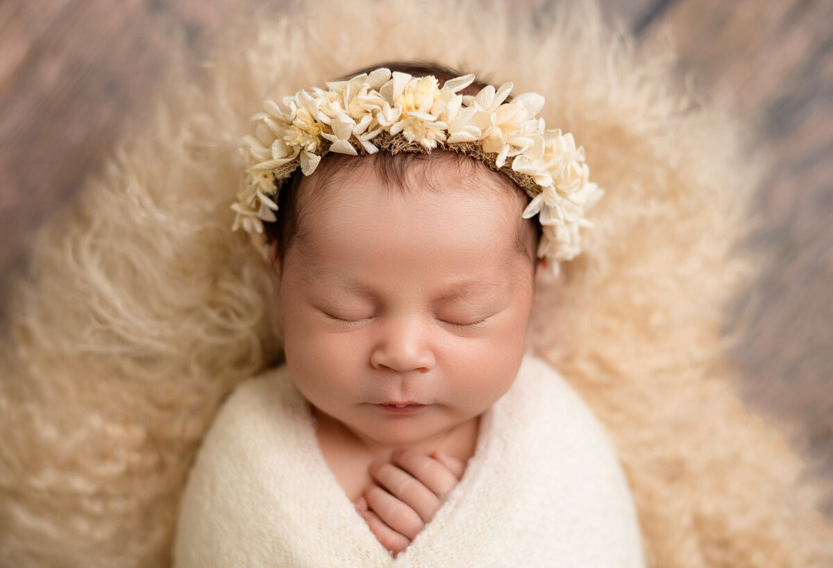 Close-up of newborn baby wrapped in soft blanket by Lissette G in Houston.