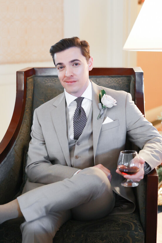 groom-sitting-in-chair-with-cocktail