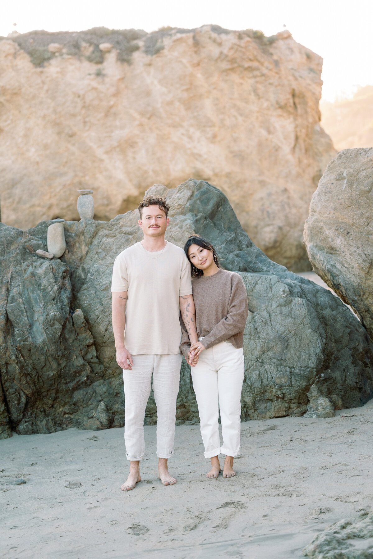 A couple holding hands and standing at the beach together