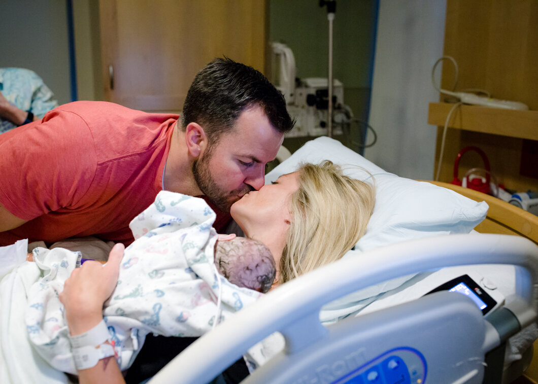 Mom and dad kiss after the birth or their new baby. Utah Birth story by Diane Owen.