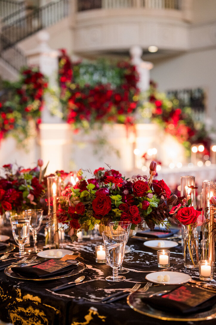 oblong arrangements, candle light, gold footed dishes, tea lights, black and white linens, gold rimmed glassware, black matte flatware
