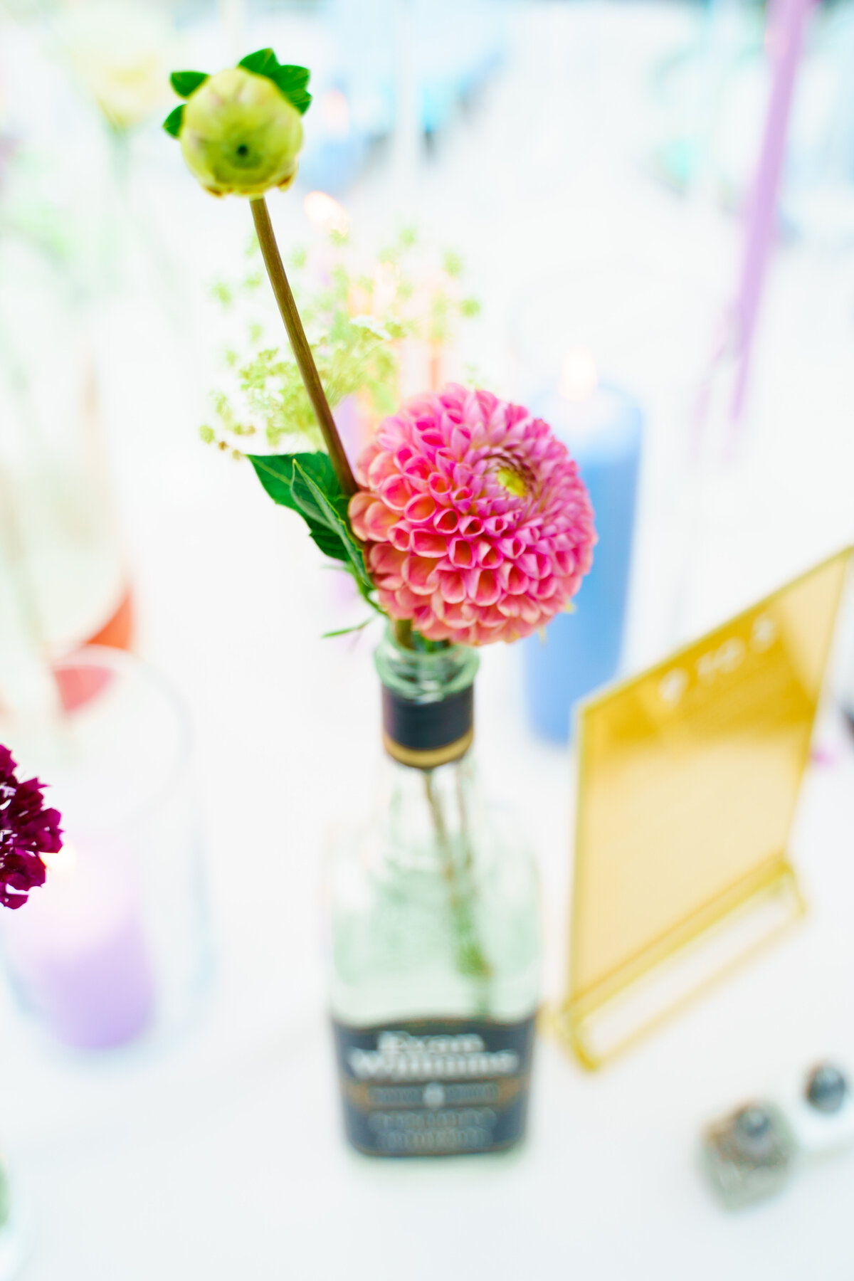A colorful tablescape with flowes in a whisky bottle in Columbus, Ohio.