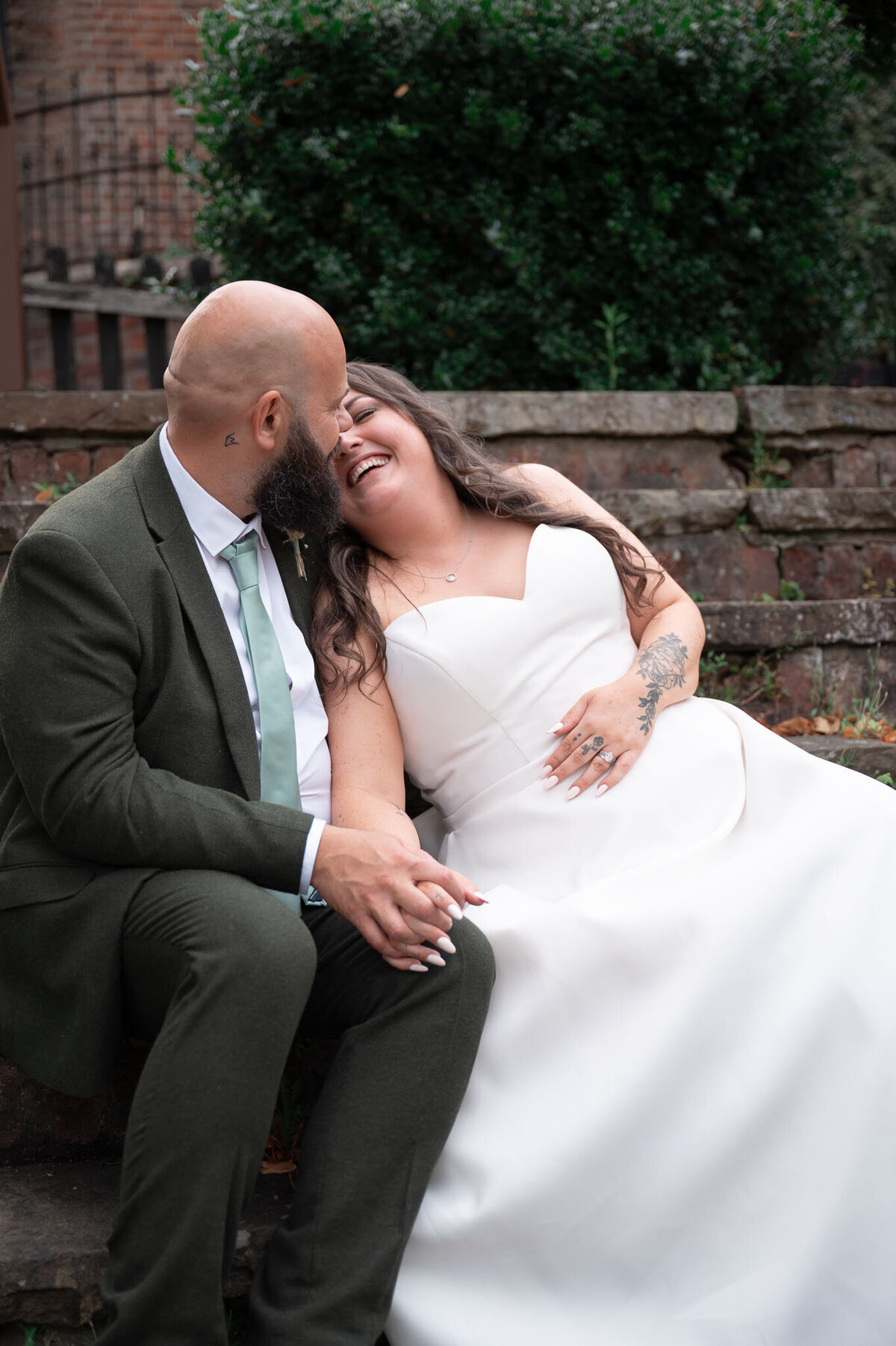 Couple laughing together on wedding day in Cheshire garden portraits.