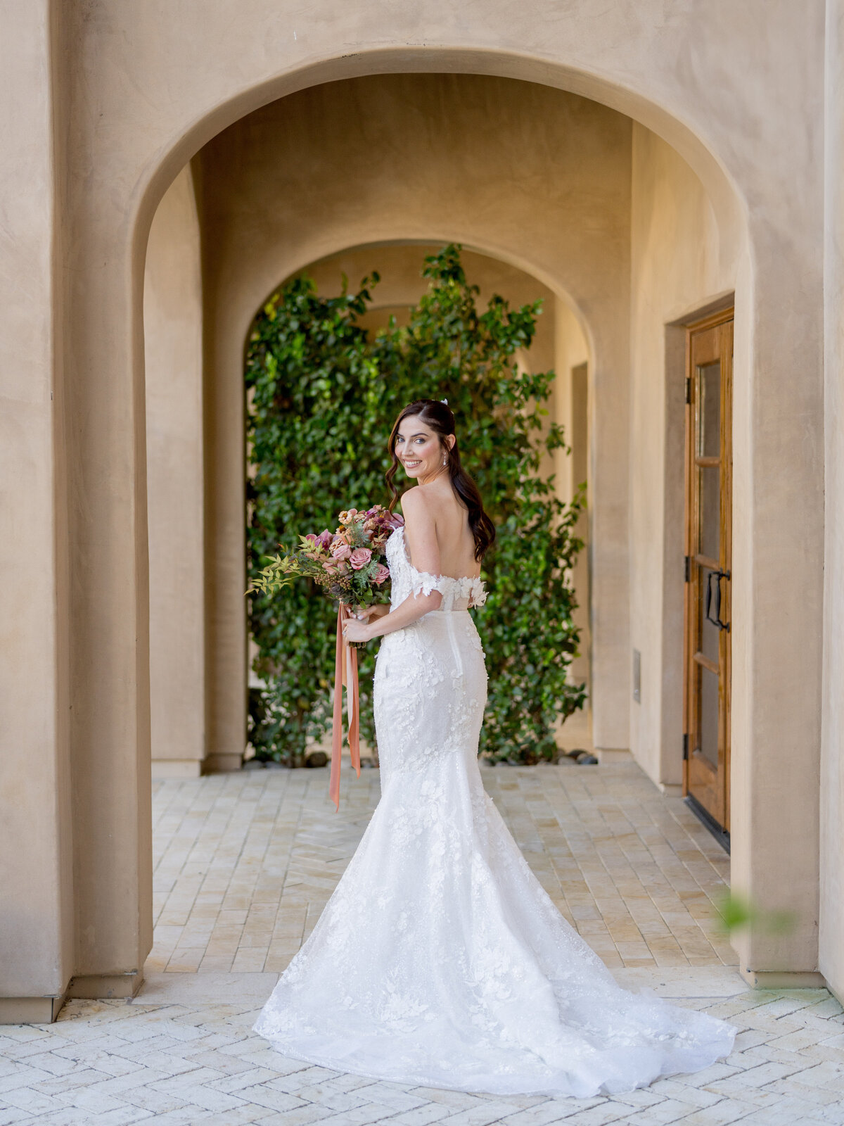 Bride holding overflowing bouquet at allegretto resort in Paso Robles during a luxury wedding