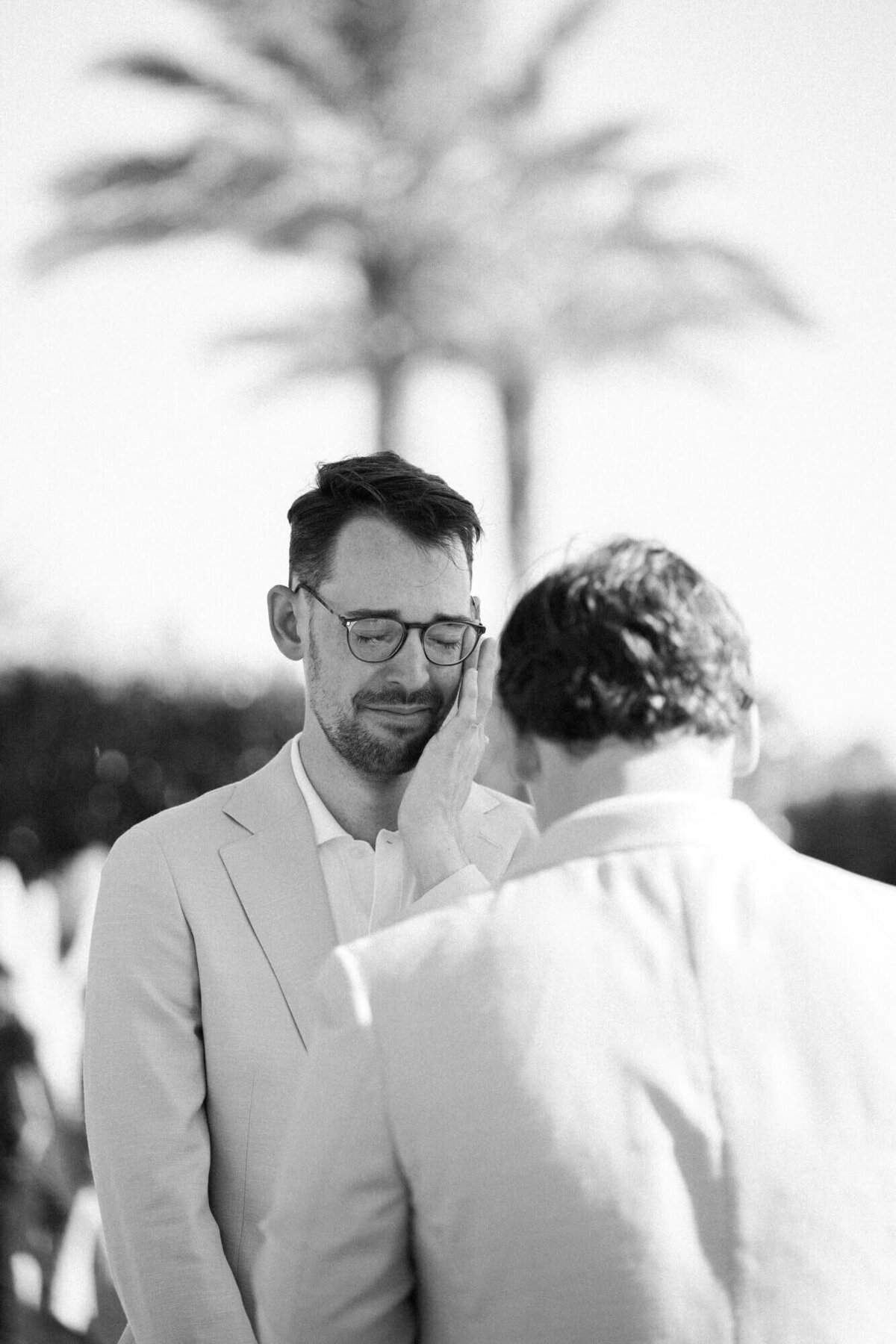 Groom wiping tears during emotional ceremony photographed by Phoenix wedding photographers at a sunny Arizona wedding.