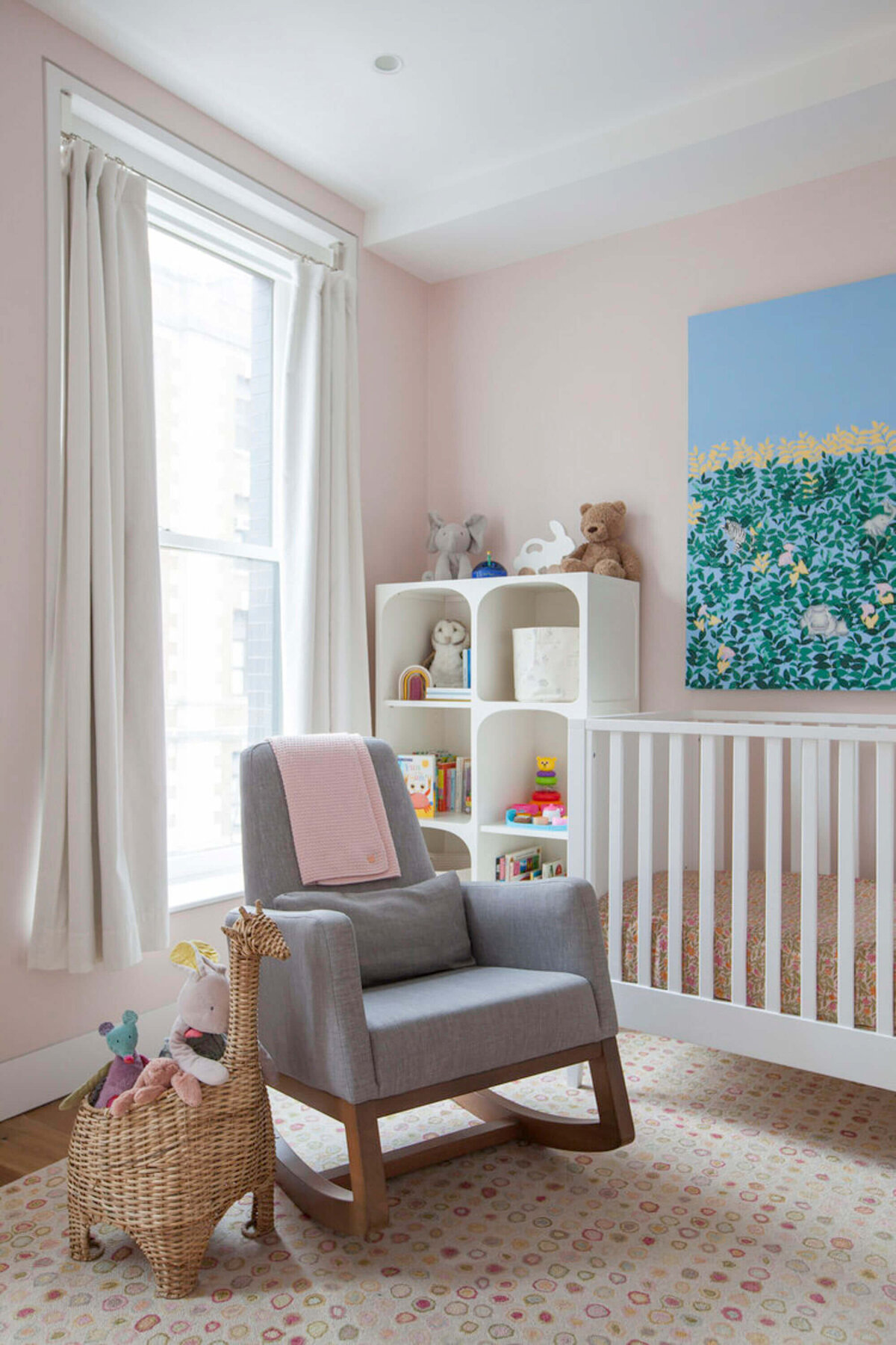 Stylish nursery with grey rocking chair and toy accents.