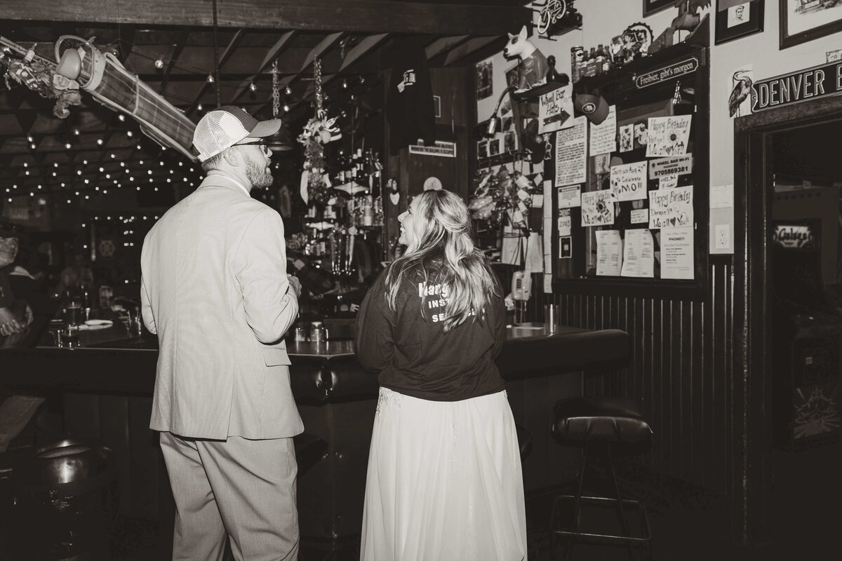 Bride and Groom Laughing at Rustic Bar