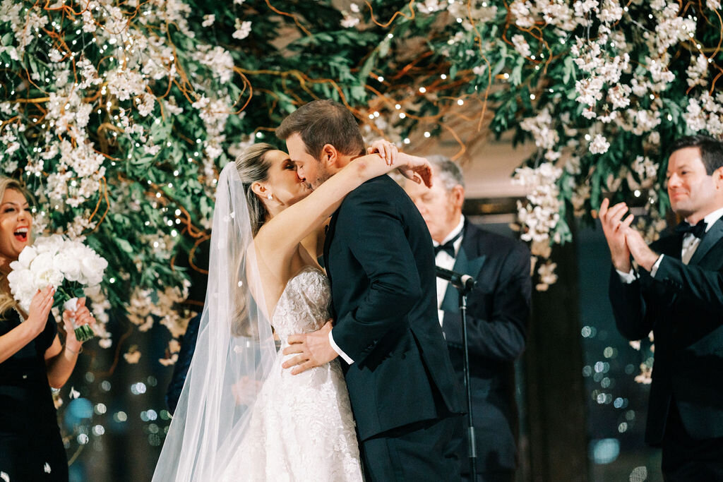 Picture of the bride and groom kissing at the wedding alter. 