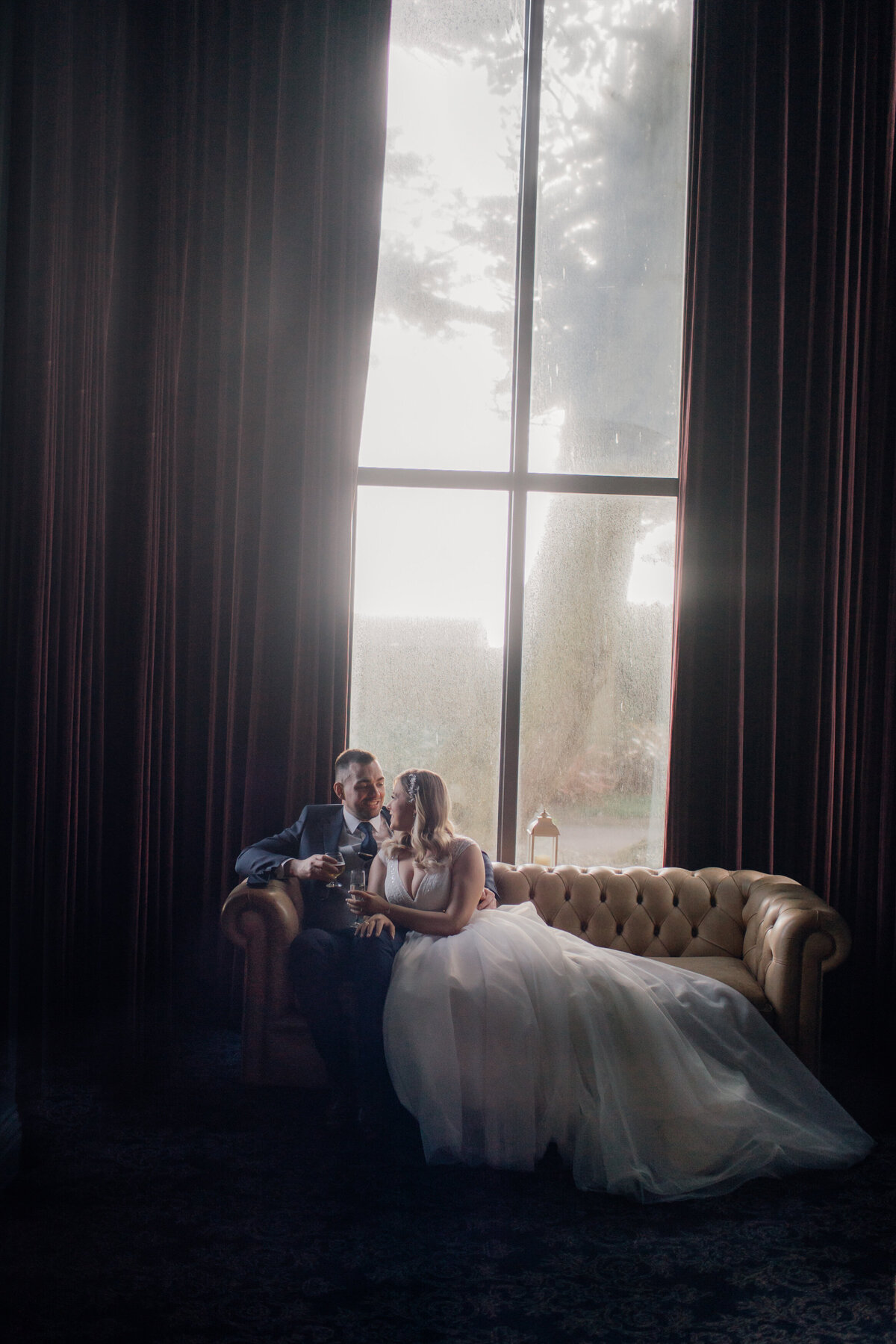 wedding-couple-relaxing-in-large-window-of-garryvoe-hotel