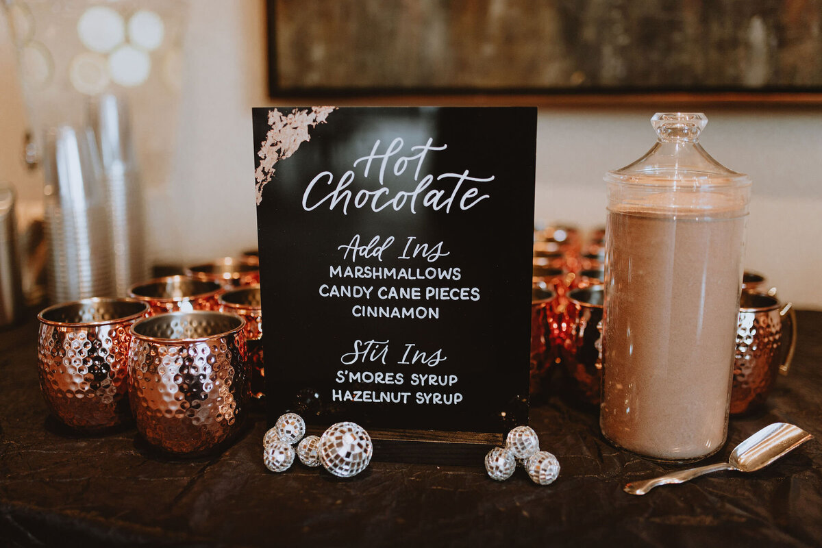 Hot chocolate sign with copper mugs and hot chocolate toppings