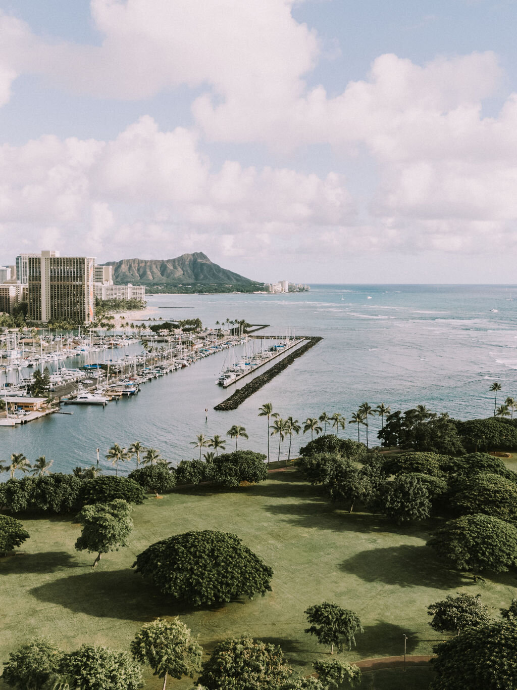 Drone view of ala moana beach park with the ocean, city scape and diamond head in the distance