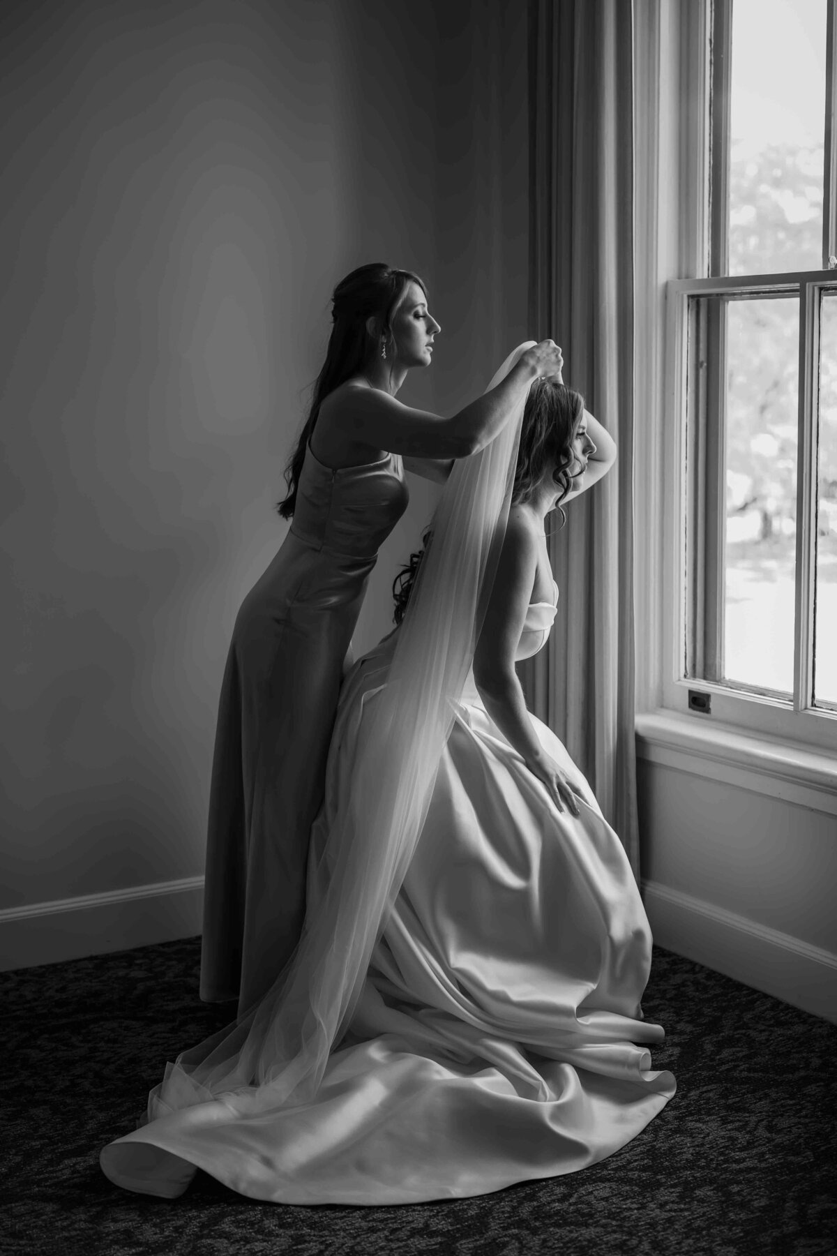 Bride gets help putting on veil at Wilder Mansion
