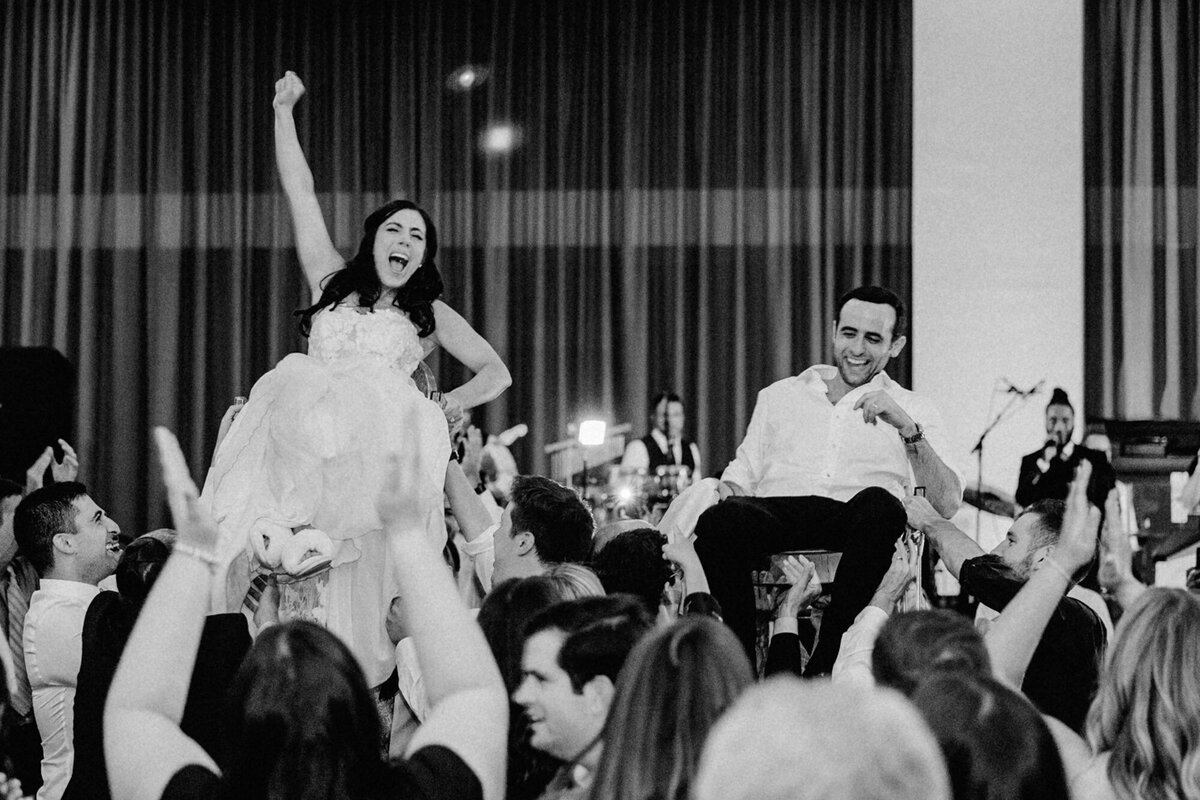 A couple does the Hora at their traditional Jewish wedding in downtown Chicago