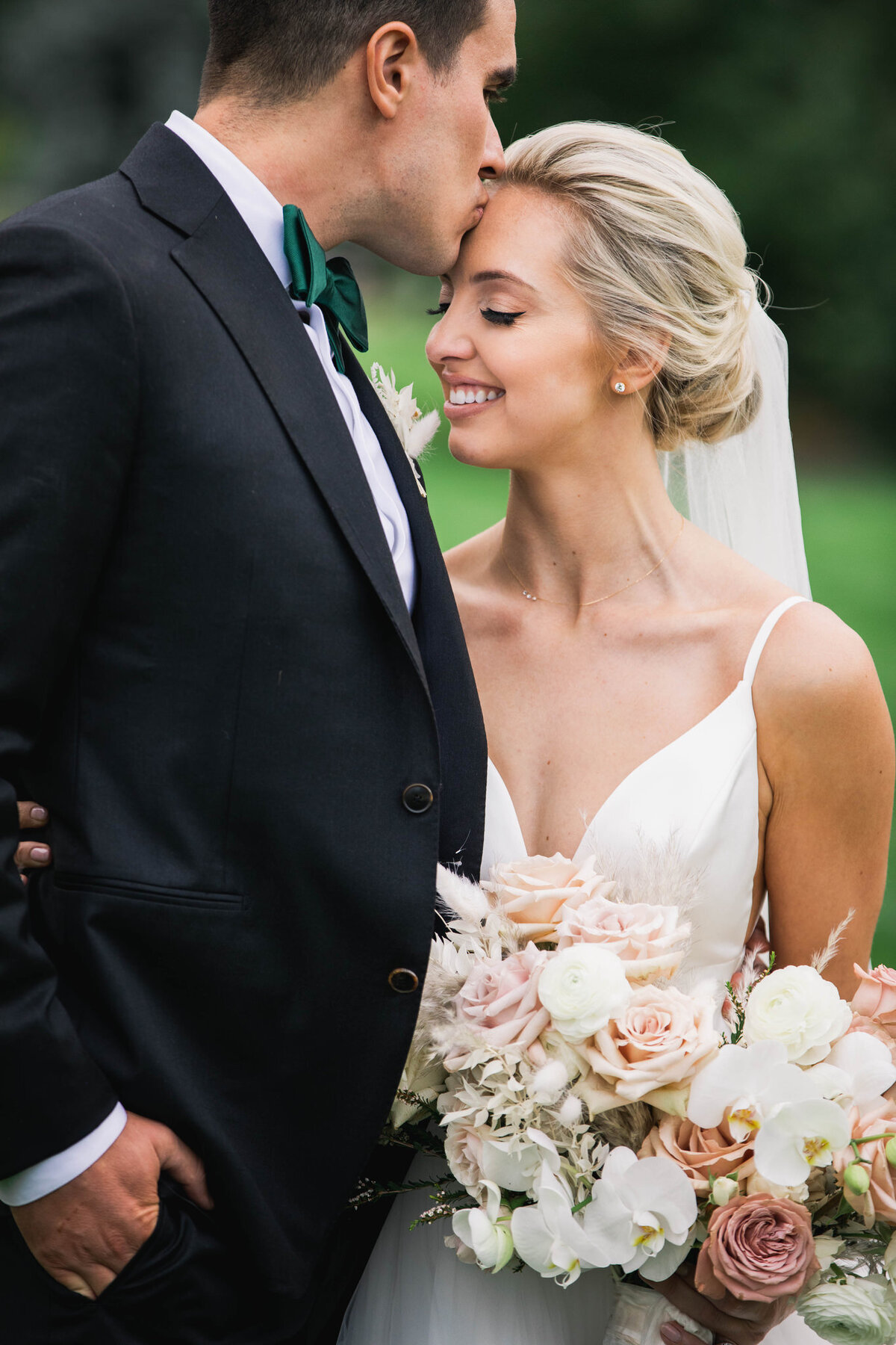 groom kissing bride's forehead