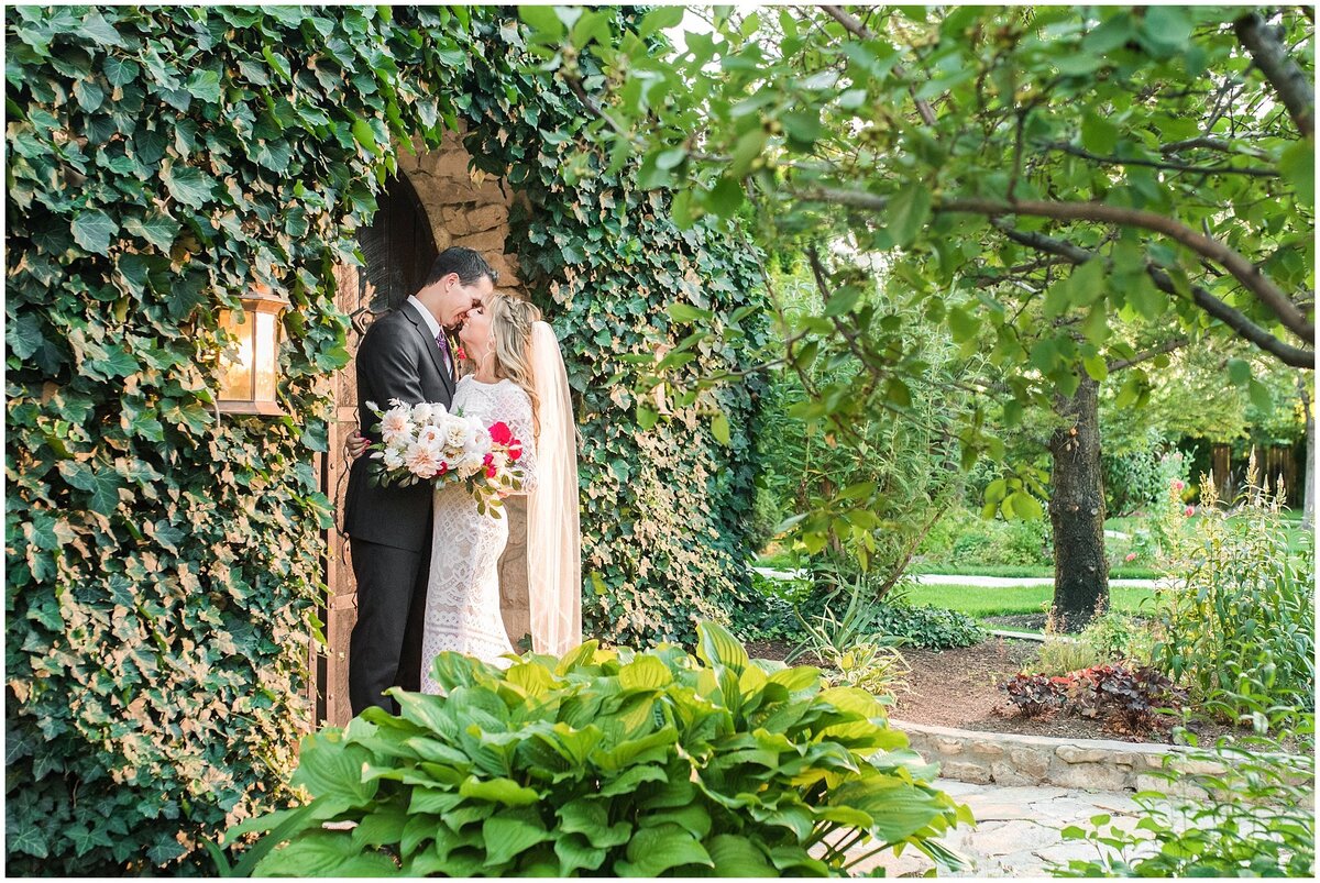 Bride and groom surrounded by vines and greenery at Wadley Farms