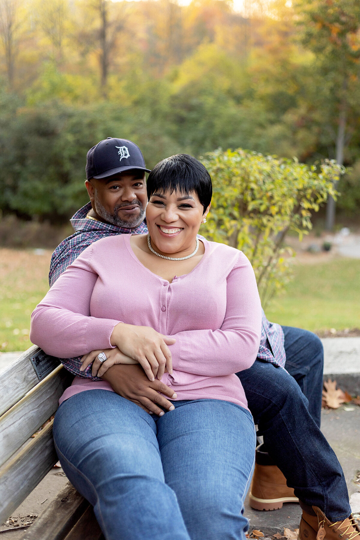 Husband and wife sitting on bench in a park