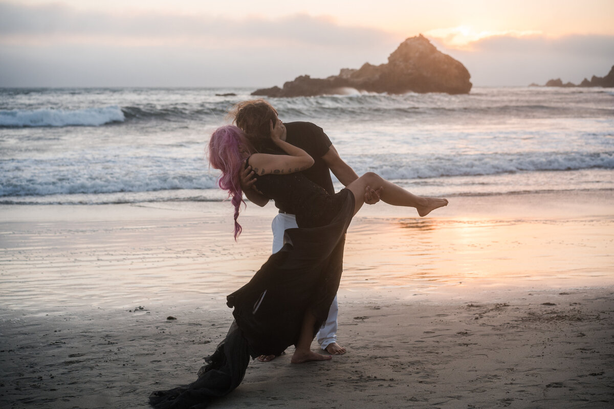 Bride and groom share a sunset kiss on a California beach