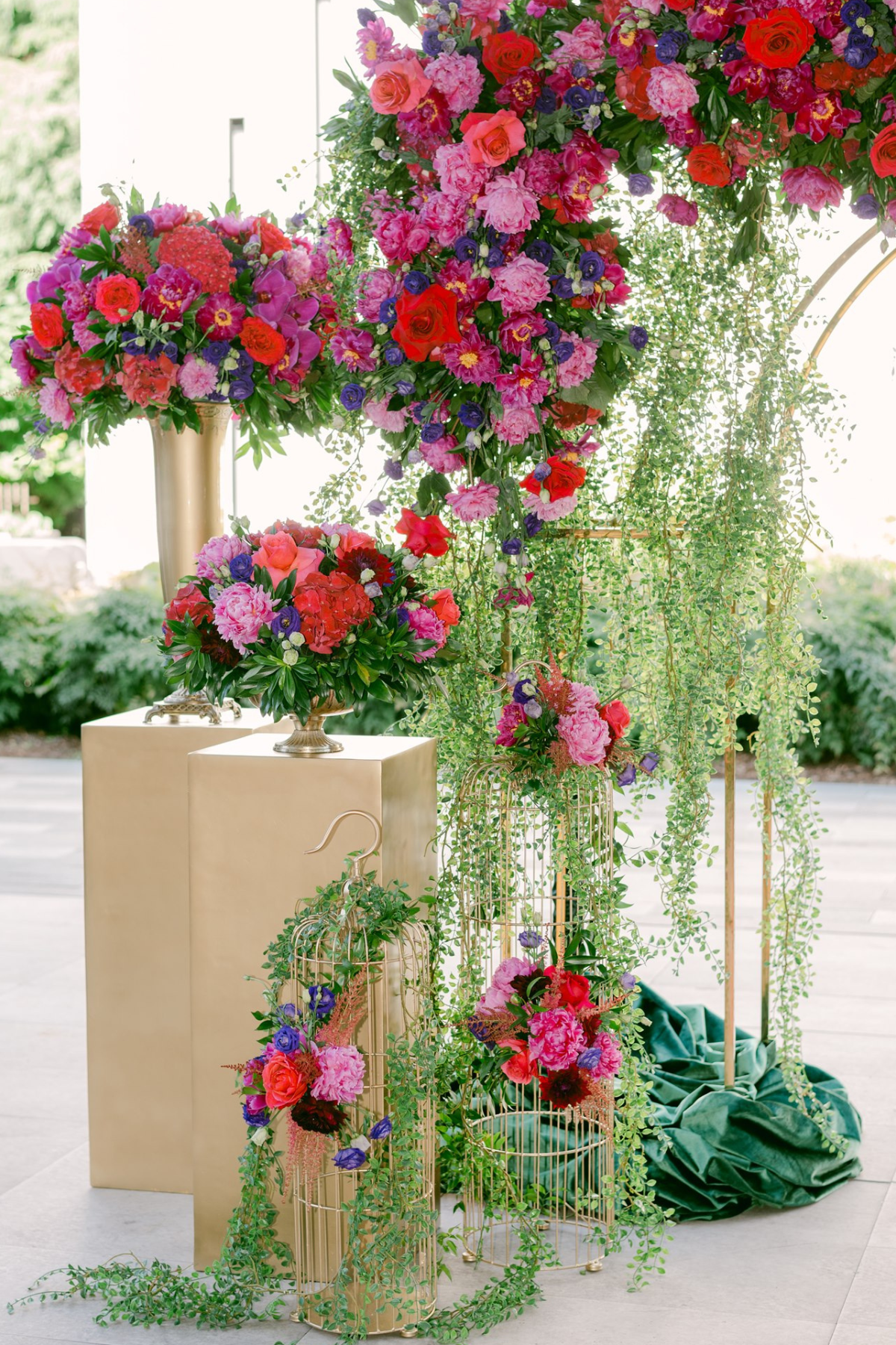 secret-garden-wedding-red-purple-pink-flowers-greenery-gold-vase-stand-arch
