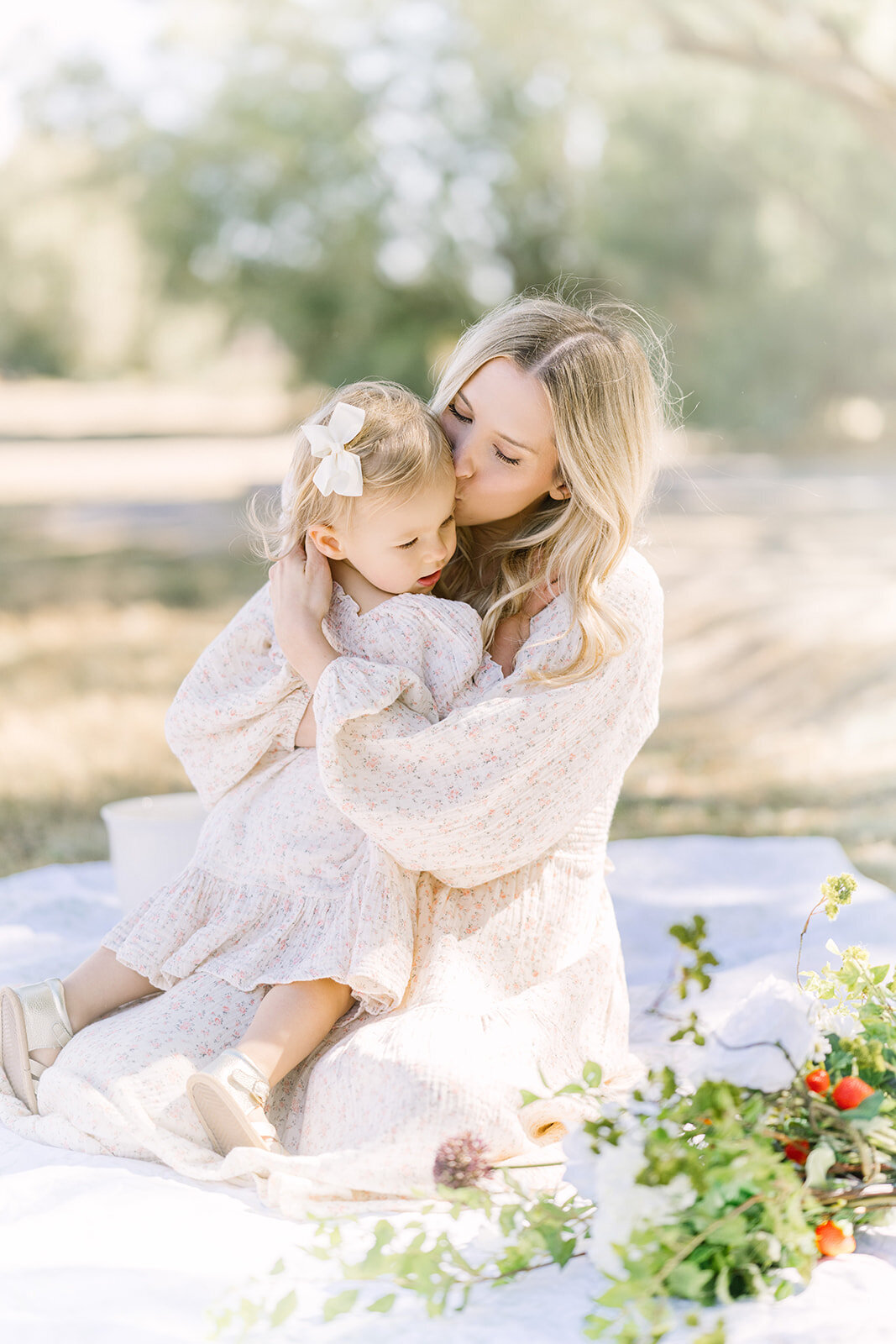 Mother and daughter embrace during a strawberry themed elegant tea party.