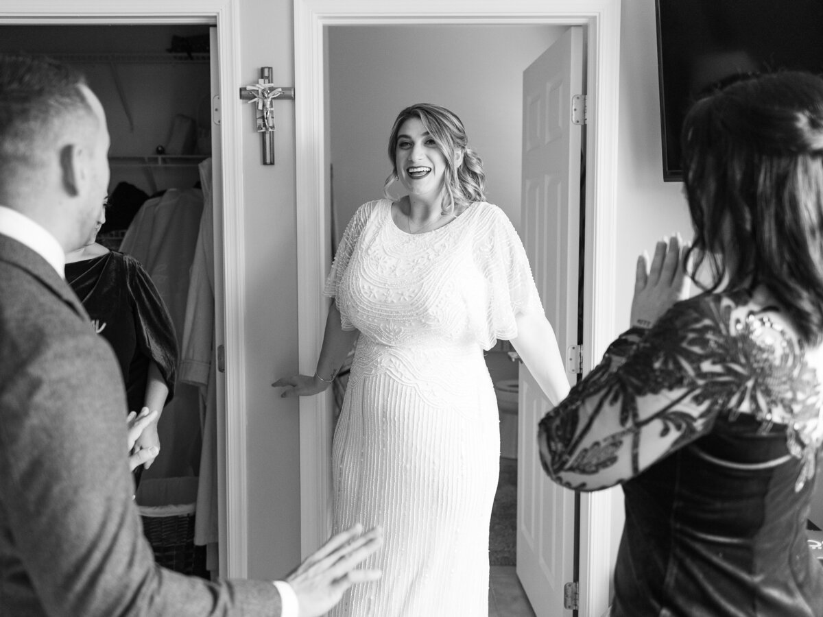 Bride walking out of room showing bridesmaids dress smiling