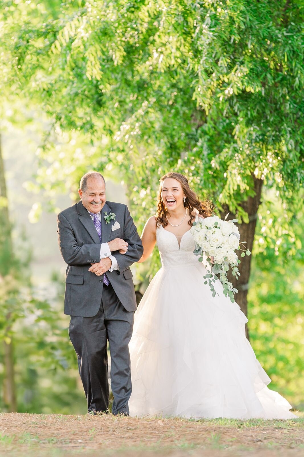 Father smiles brightly as he walks his daughter down the aisle