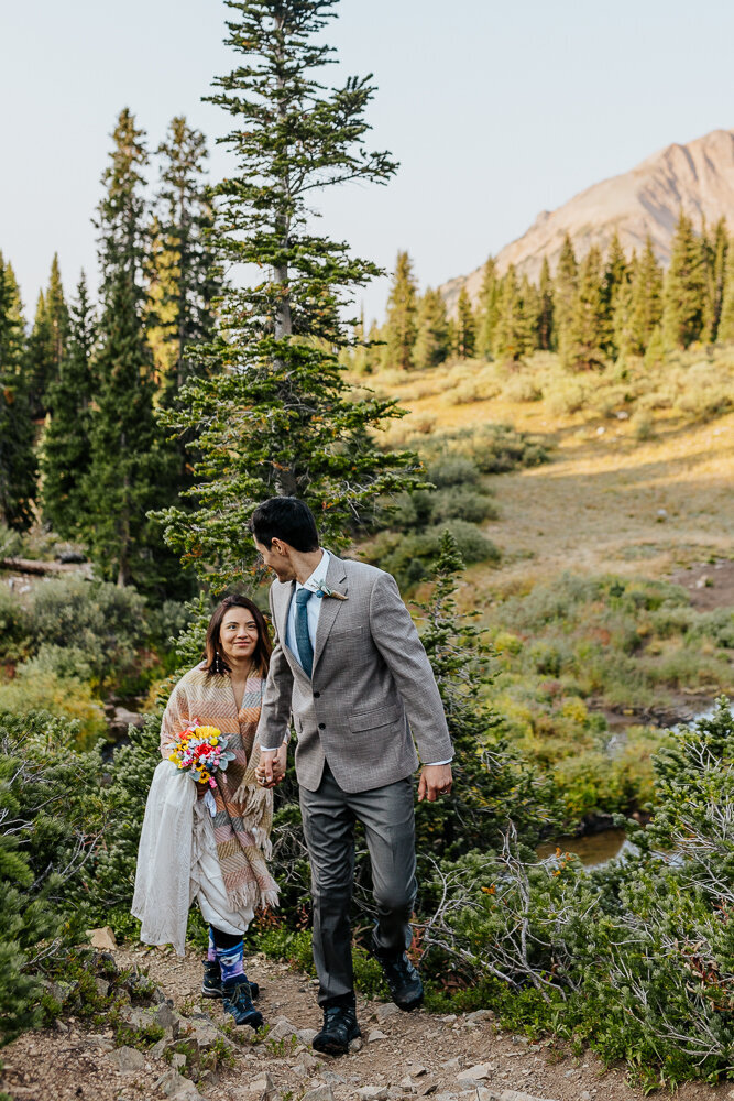 A couple walks up a mountain during their elopement in Crested Butte.