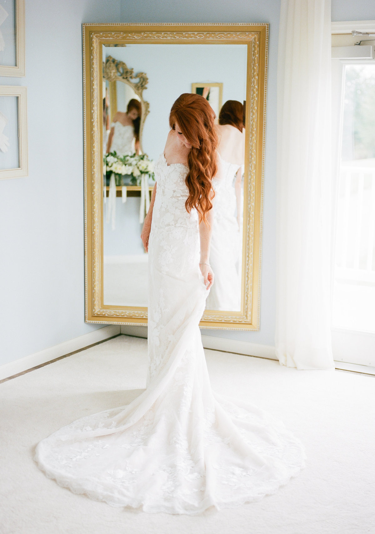 bride looking down at wedding  dress while getting ready