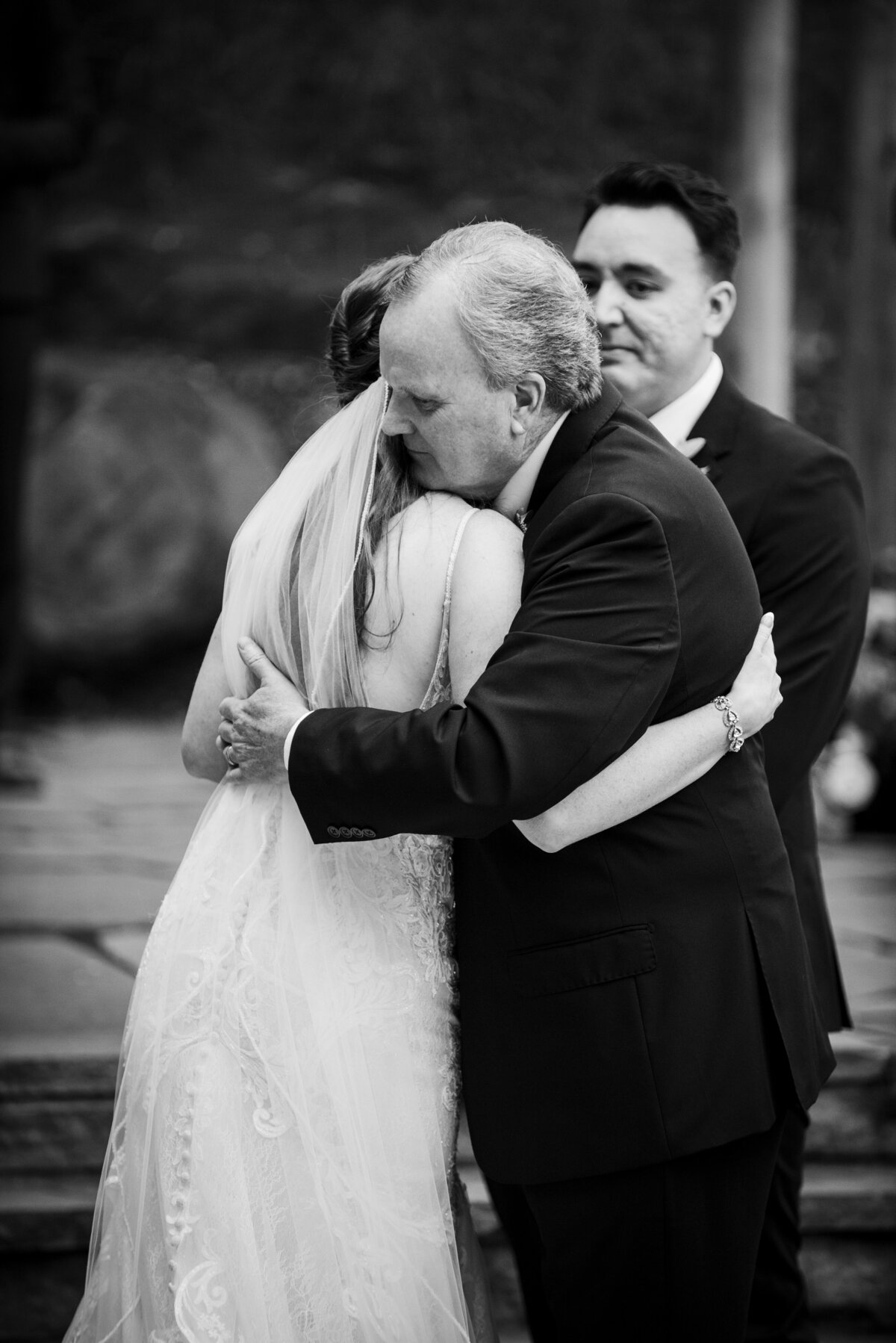 A bride shares a hug with her father as he gives her away during the ceremony.