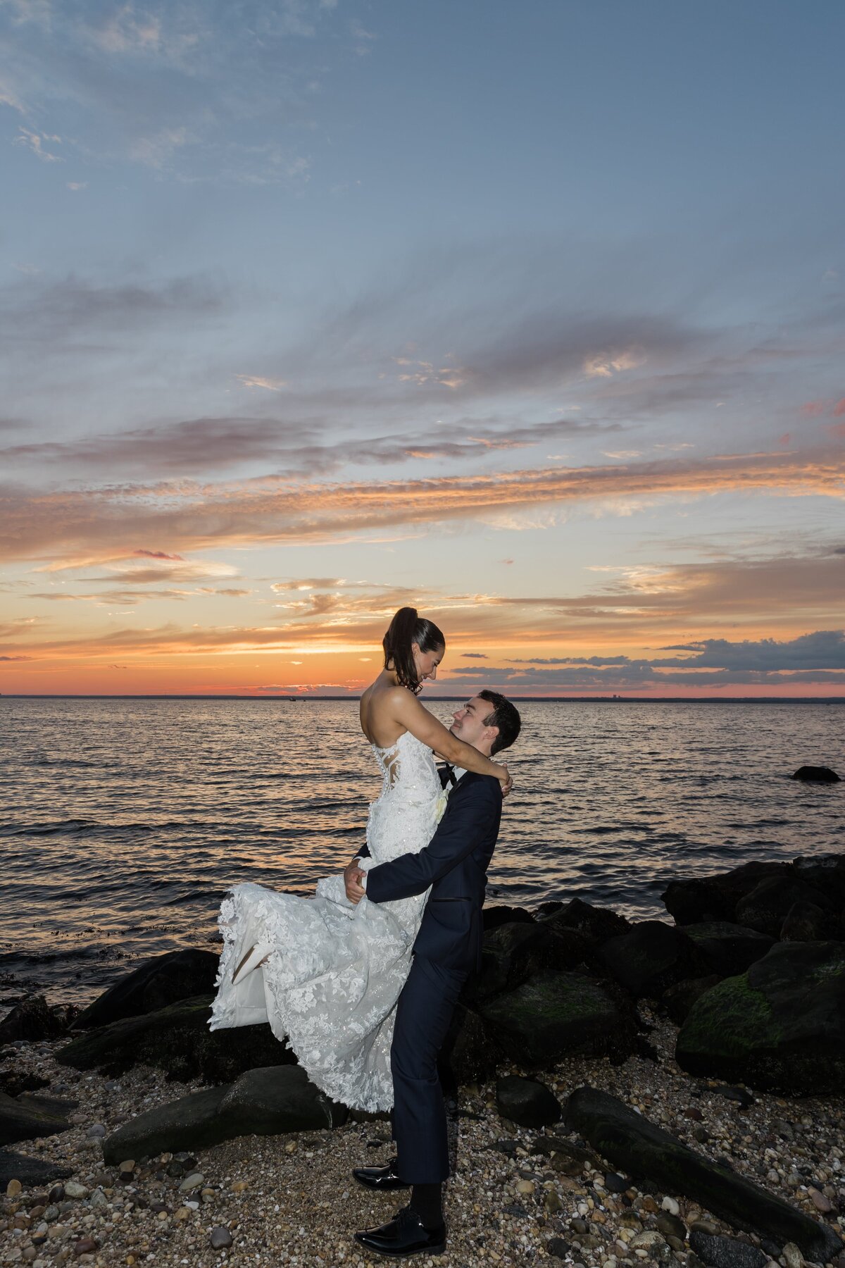 Groom lifting up bride on a beach in Long Island New York