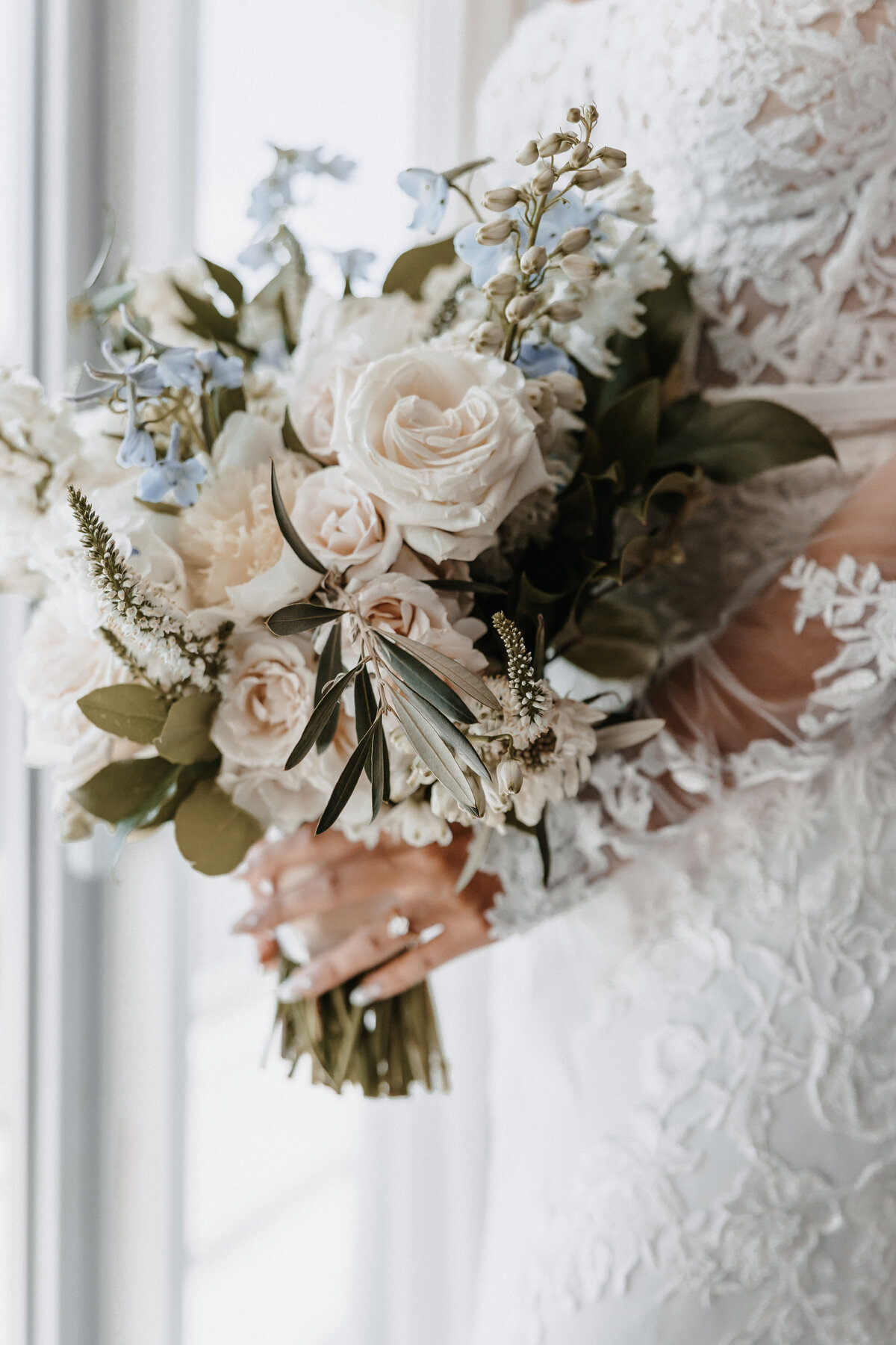 Bride in lace wedding dres holding floral bouquet