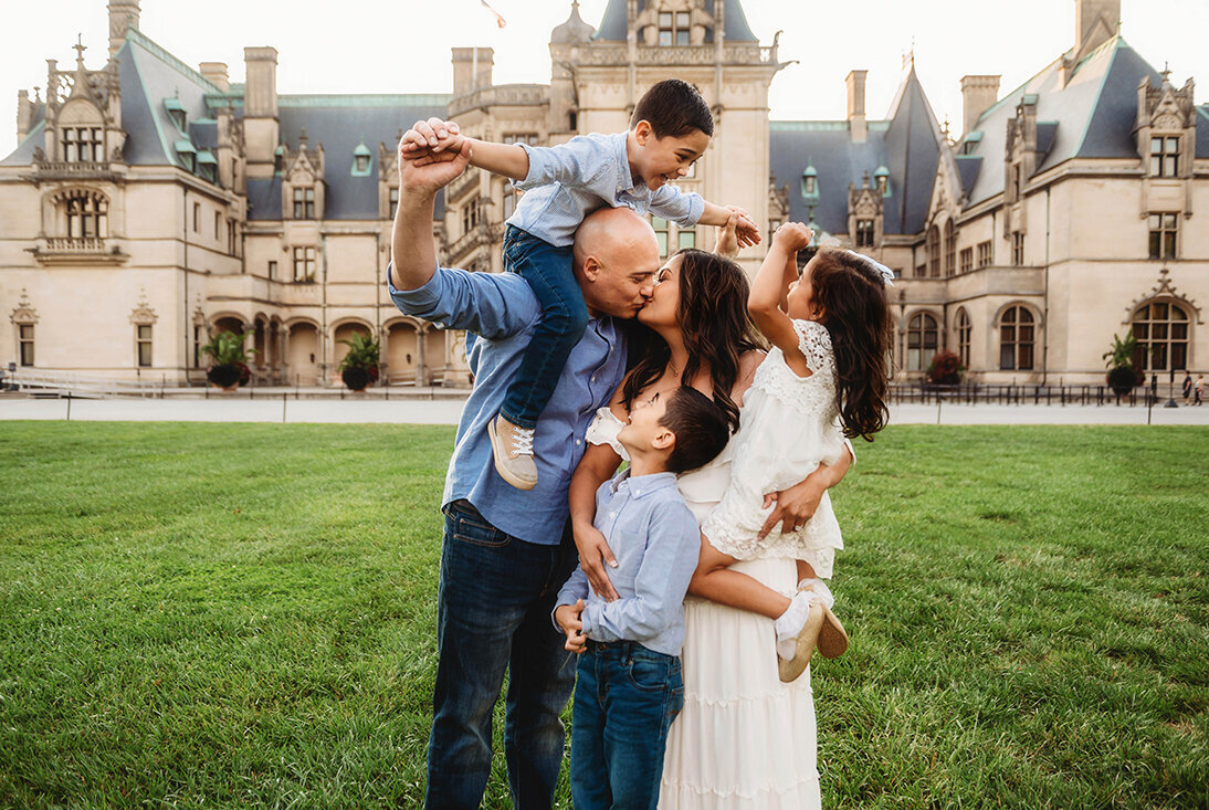 Family poses for portraits in front of Biltmore Estate in Asheville, NC,