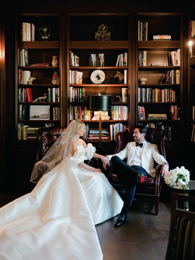 Classic wedding portrait of couple sitting in the Library and talking together at their wedding in Salamander Resort.