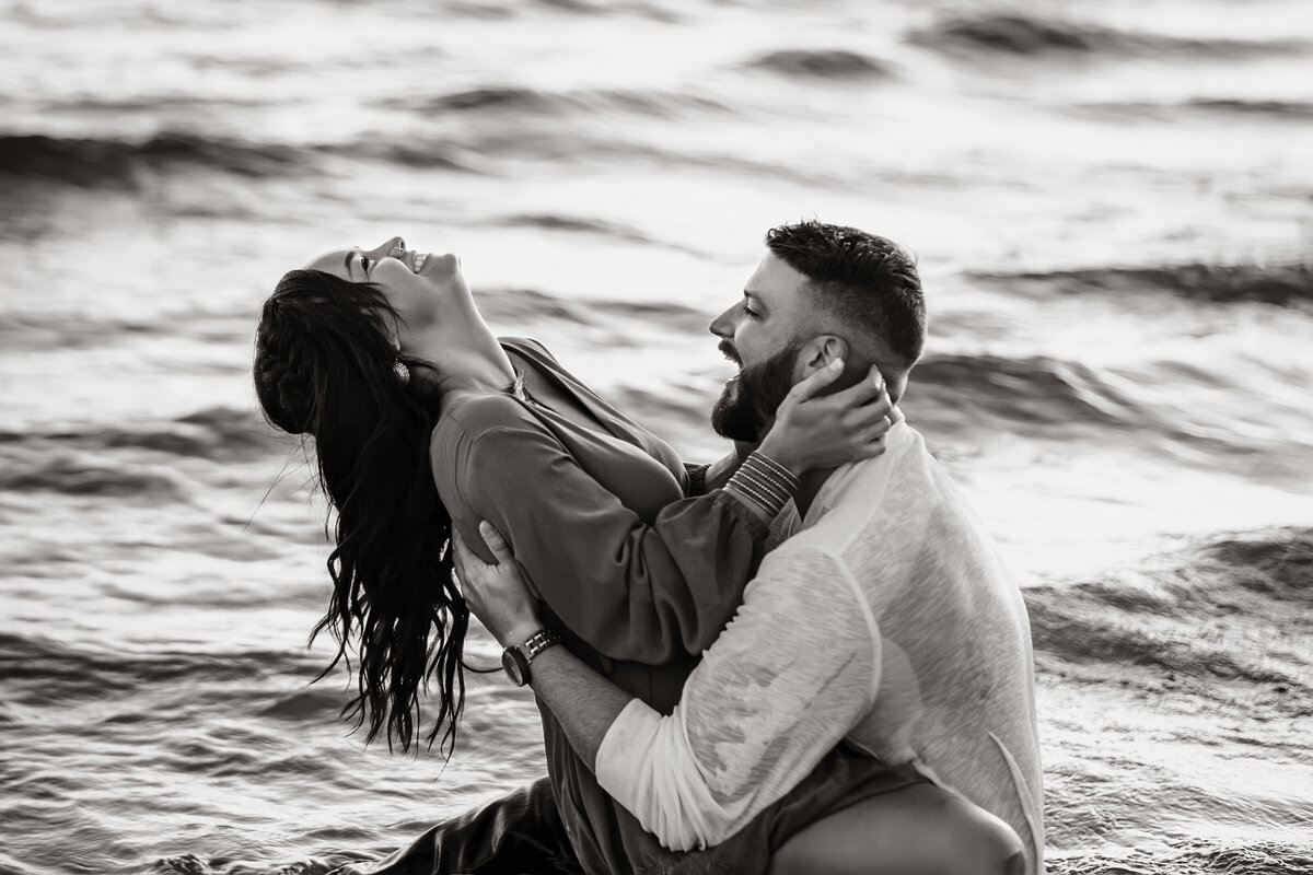 couple in water engagement session grand haven