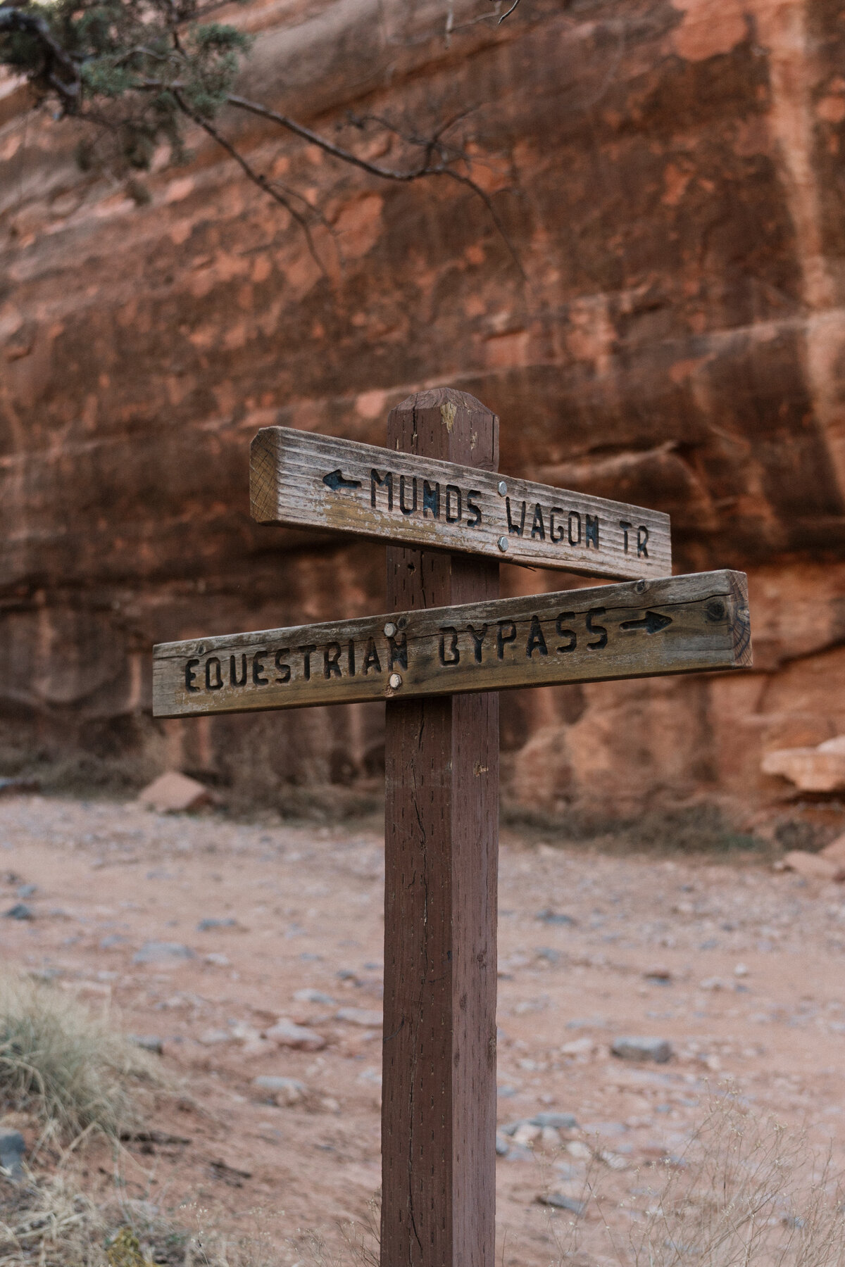 Wooden trail sign at Munds Wagon Trail and Equestrian Bypass near Merry Go Round Rock in Sedona, captured during a rustic desert elopement surrounded by red rock formations.