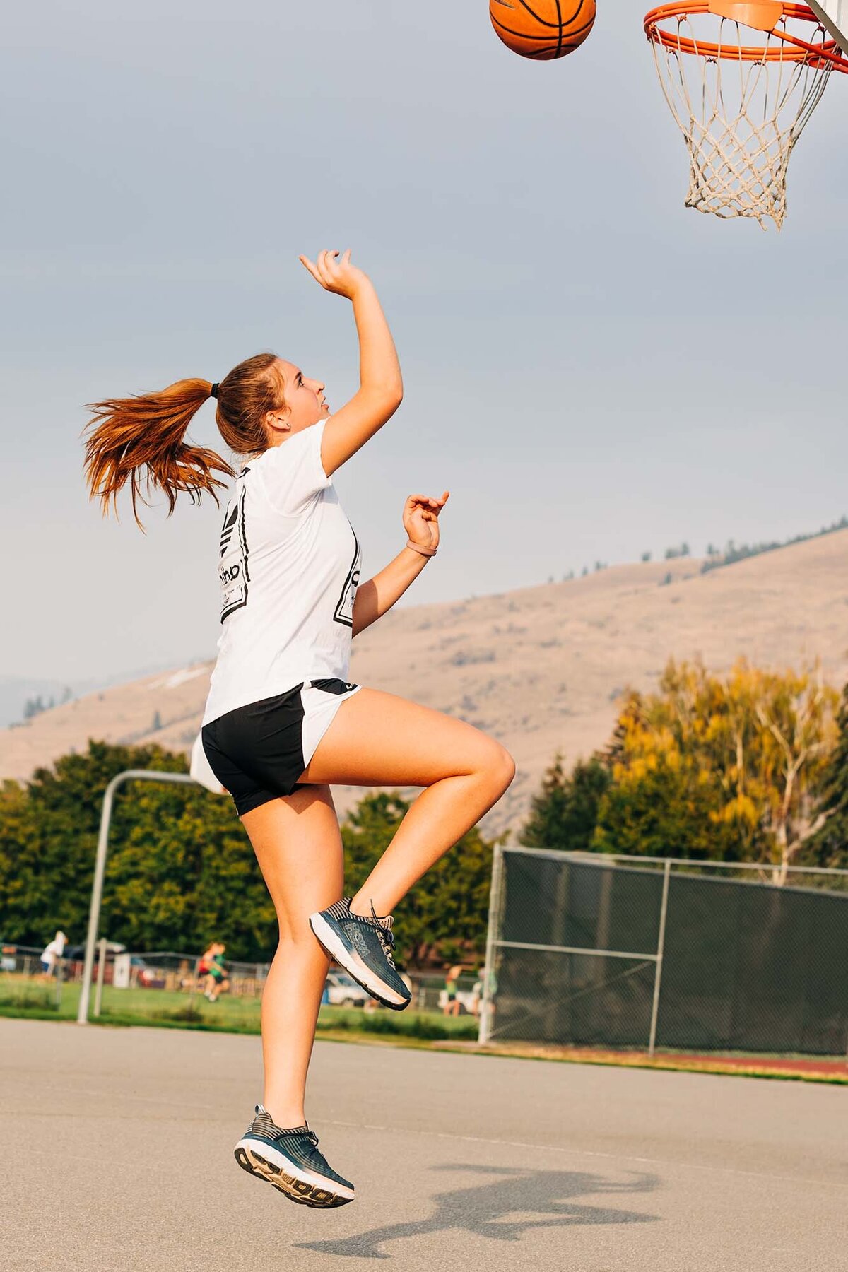 Girl practicing basketball hoops at Playfair Park, Missoula