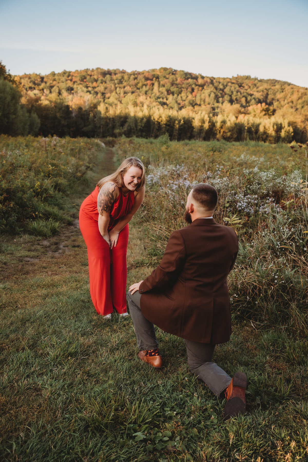 A couple surrounded by Vermont's vibrant fall foliage, reflecting the season of change and love.