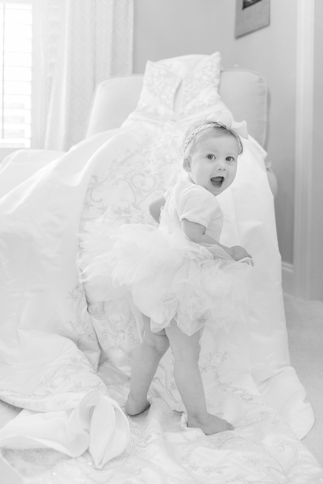 Toddler standing on wedding gown