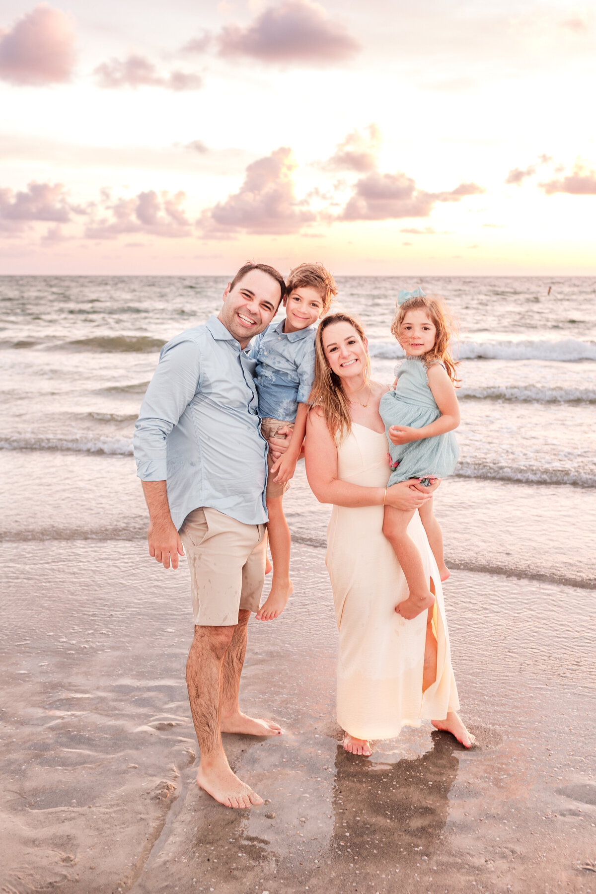 Family gathered on the beach dunes with Clearwater waves in the distance.