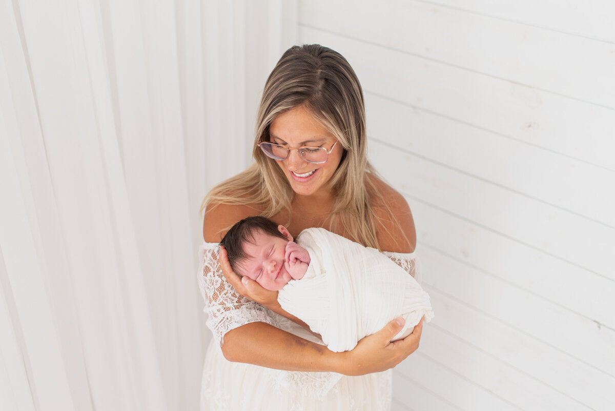 Mother smiling down at newborn son