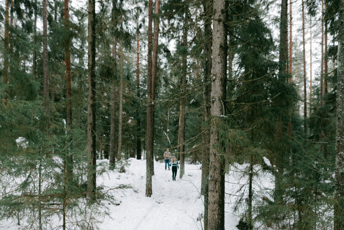 Kihlapari metsässä talvisessa kihlakuvauksessa valokuvaaja Hannika Gabrielssonin ottamassa valokuvassa