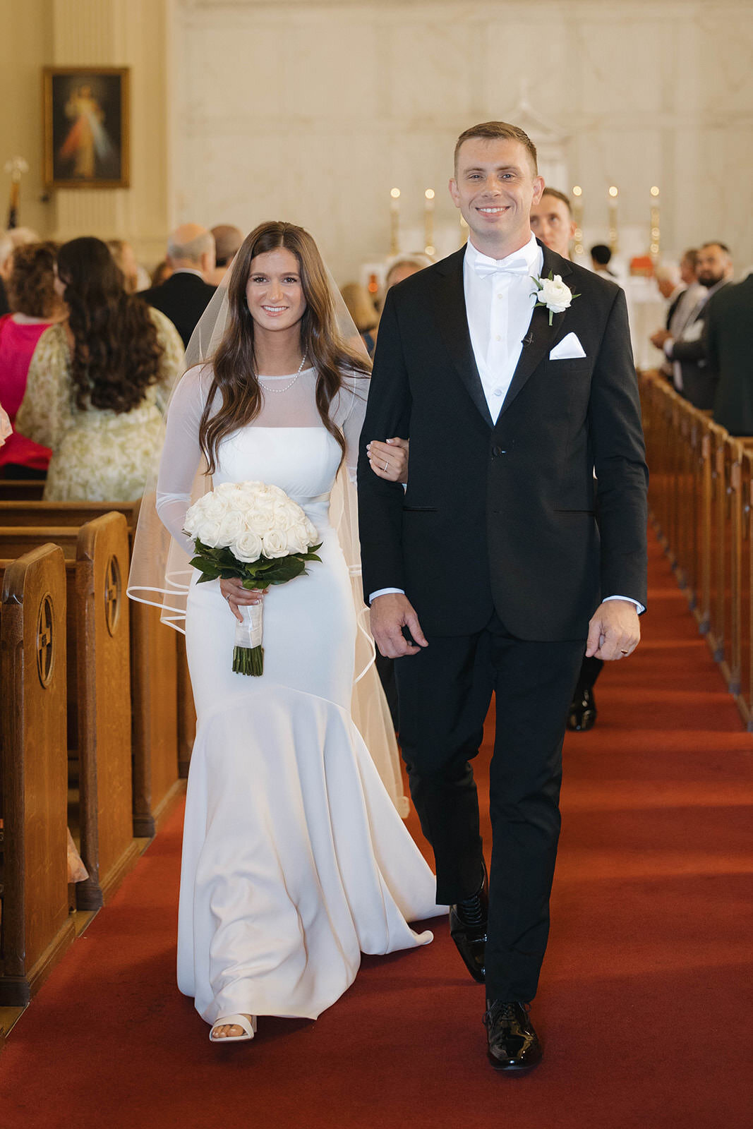 Bride and groom walking up the church aisle