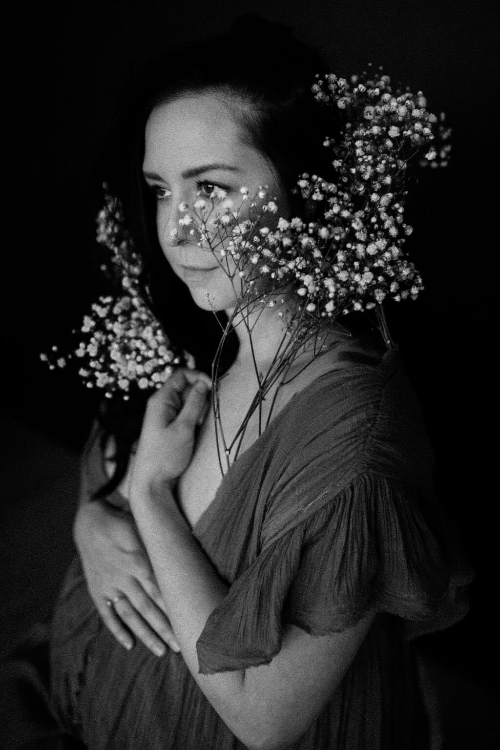 black and white image woman sitting holding flowers